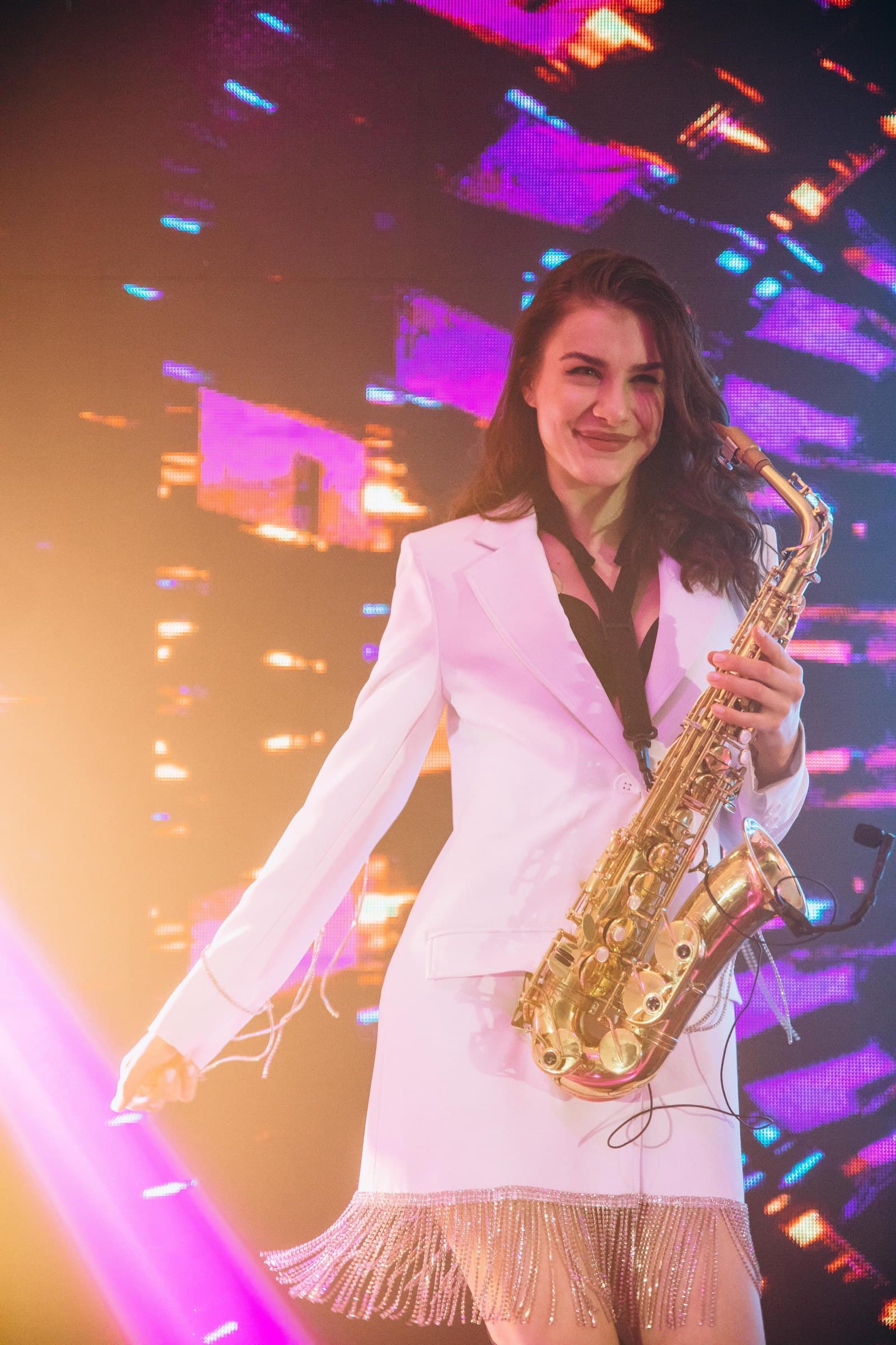 Violetta performing live saxophone under club lighting